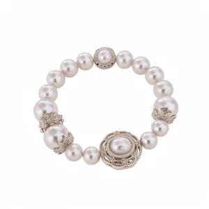 Elegante pulsera elástica de perlas y circonitas con motivos metálicos florales decorativos