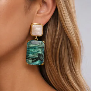 Detailaufnahme der smaragdgrünen Harzohrringe mit Marmortextur und Goldrahmen im Retro-Stil