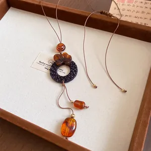 Détail d'un collier en cuir de style chinois avec des perles de bois ambrées élégantes