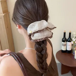 Elegant vintage polka dot oversized scrunchie worn on a braided hairstyle for a chic look.