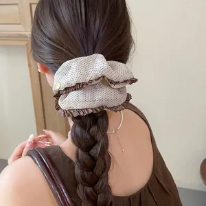 Detail of retro polka dot scrunchie with coffee ruffles worn in a braided hair
