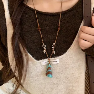 Gros plan d'un collier pendentif turquoise style New Chinese avec perles
