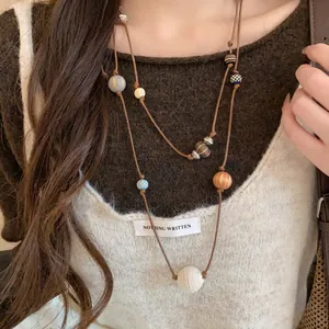 Détail d'un collier long à double couche en cuir avec perles en bois style néo-chinois