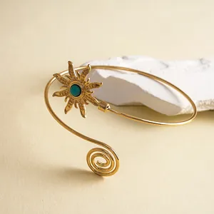 Gedetailleerde weergave van een gouden vintage armring met zon en blauwe edelsteen