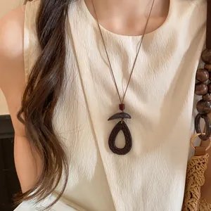 Gros plan détaillé d'un long collier de style néo-chinois avec perles en bois et cordon
