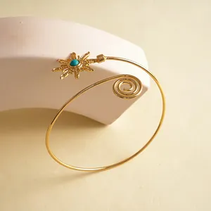 Detailweergave van een vintage gouden zonnebloem armband met een turquoise steen