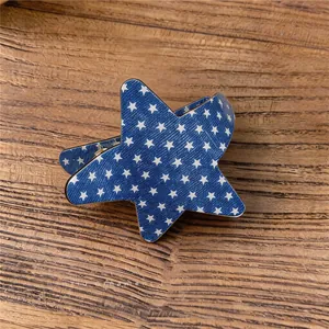 Vista detallada de pinza para el pelo con forma de estrella azul y estrellas blancas