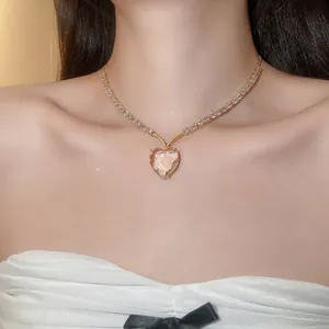 Gedetailleerde opname van een vintage hartvormige ketting met glinsterende zirkonia op een model