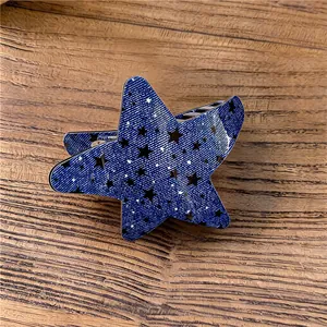 Primer plano de una pinza para el pelo con forma de estrella azul y patrón de denim