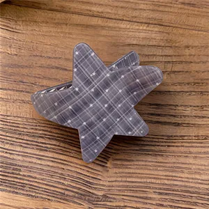 Detalle del patrón de cuadros grises y estrellas en una pinza para el pelo de estrella.