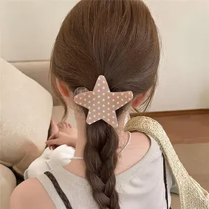 Detalle de una pinza para el pelo con forma de estrella elegante y estampado de estrellas.