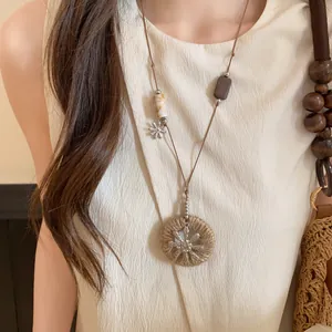 Vue détaillée d'un collier long de style chinois moderne avec perles en bois et pendentif