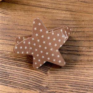 Vista detallada de una pinza para el cabello de acrílico marrón con forma de estrella