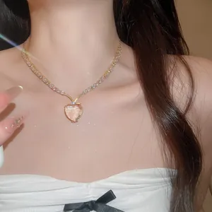 Detailopname van vintage hartvormige ketting met sprankelende zirkonia en roze kristal