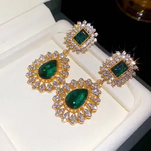 Vintage court style earrings with emerald green teardrop pendants and rhinestones