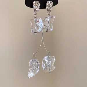 Gros plan détaillé de boucles d'oreilles pendantes en acrylique froissé avec base en argent