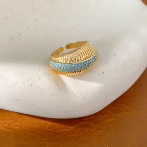 Dettaglio anello aperto placcato oro 18k con zirconi turchesi e texture a coste