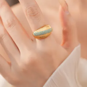 Dettaglio ravvicinato di un anello a costine placcato oro 18k con pietre turchesi