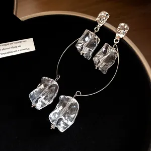 Détail de boucles d'oreilles carrées de style coréen avec métal argenté et acrylique.