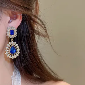 Detail view of vintage palace style earrings with elegant blue water drop rhinestones