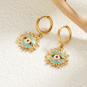 Vue détaillée des boucles d'oreilles soleil œil du diable en émail bleu et métal doré
