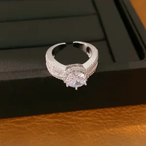 Detailansicht eines 18 Karat vergoldeten Rings mit rundem Zirkon und Pavé-Steinen