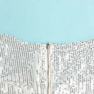 Detailed close-up of a golden zipper and sparkling white sequins on a sexy bodycon party dress