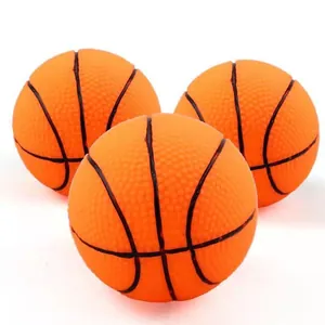 Close-up of three orange squeaky basketball dog toys with textured vinyl surface