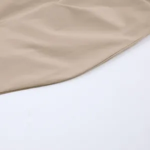 Detailopname van de gladde beige stof en nette stiksels van een Franse overhemdjurk