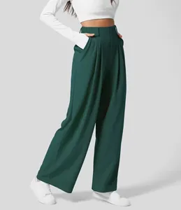 Detail von dunkelgrüner Hose mit hoher Taille, weitem Bein und elegantem Faltenwurf.