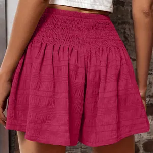 Close-up detail of women's magenta high-waisted smocked shorts with crinkle texture