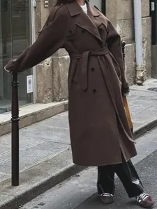 Elegant long brown double-breasted trench coat perfect for chic autumn street style