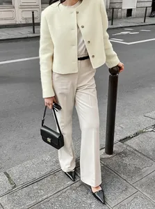 Elegante cremefarbene Tweed-Kurzjacke mit beiger Hose in einer Streetstyle-Ansicht