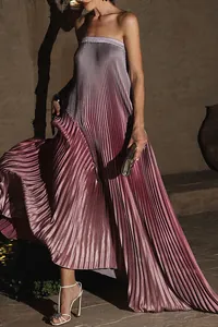 Détail d'une robe longue plissée dégradée sans bretelles dans un décor de soirée