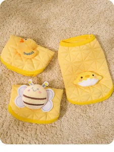 Detailed view of yellow quilted puppy vests featuring cute 3D plush animal decorations.