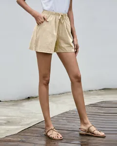 Detalle de los pantalones cortos de lino de corte en A para mujer con cordón en beige