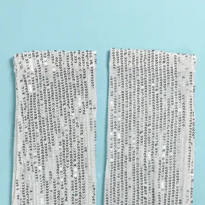 Macro view of silver sequins on a white mesh fabric for a glamorous evening dress