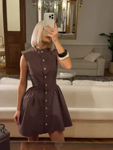 Elegant French vintage brown sleeveless waist-nipping A-line dress shown in home setting