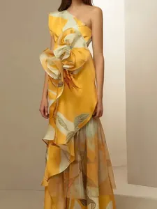 Elegant yellow one-shoulder maxi dress featuring a large waist ruffle and leaf print
