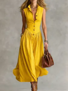 Elegante gele mouwloze maxi-jurk met een lijfje met knopen en een wijde rok.