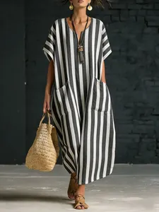 Macro view of woman wearing a loose black and white striped V-neck dress with pockets