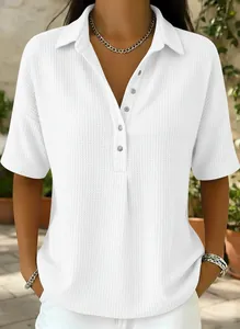 Détails d'un polo blanc en maille gaufrée, manches courtes et boutonnage frontal.
