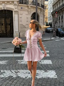 Charming detail view of a pink French lace mini dress with puff sleeves and deep V-neck.