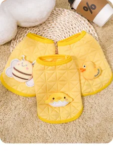 Detailed view of yellow quilted puppy vests featuring cute cartoon patches for autumn