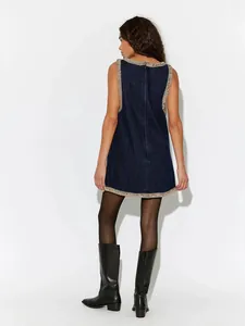 Elegant dark denim sleeveless mini dress with sparkling rhinestone trim on model back view