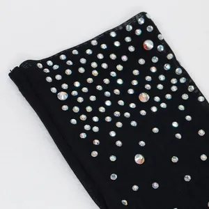 Dettaglio macro di strass iridescenti su tessuto a rete nero di questo body sexy