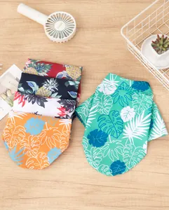 Detailed view of vibrant Hawaiian style dog shirts featuring tropical leaf and pineapple prints