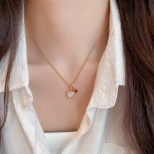 Primo piano di collana a cuore placcata oro 18k con pendenti in zircone e madreperla