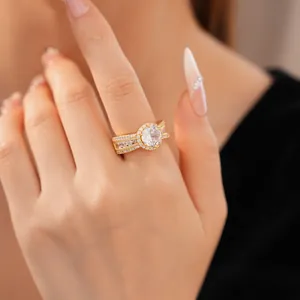 Exquisite Nahaufnahme eines 18 Karat vergoldeten runden Zirkonia-Rings am Finger der Frau