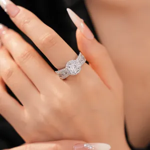 Detailansicht eines 18 Karat vergoldeten Rings mit rundem Zirkonia-Halo am Finger.